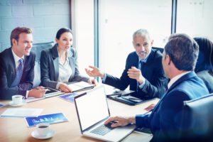 Professionals discussing long-term unemployment solutions around a conference table.