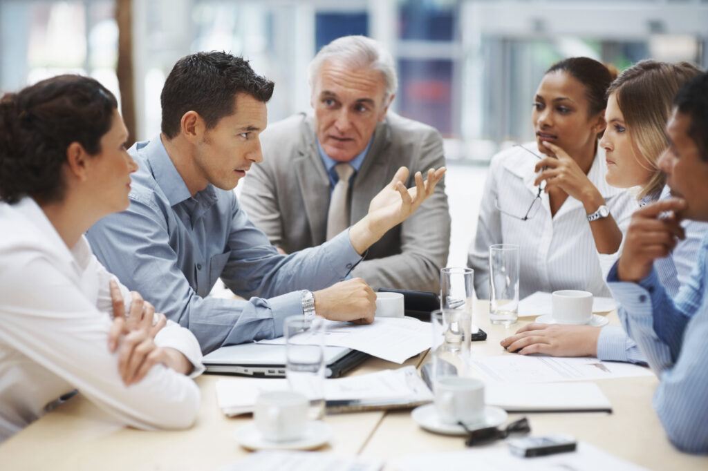 Business team sitting around the conference table discussing payroll costs