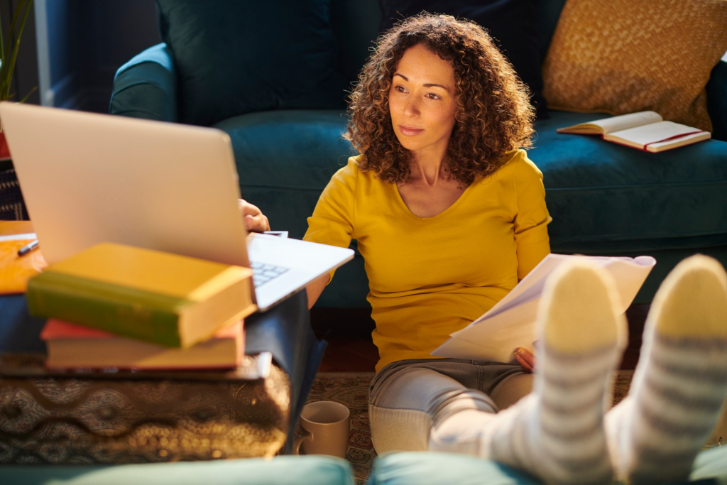 Focused woman working on laptop while sitting on the floor, embodying Social Media Job Success strategies.