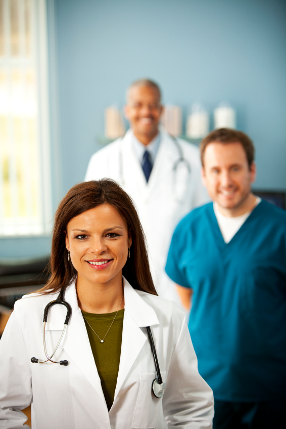Woman Physician standing in front of her male colleagues